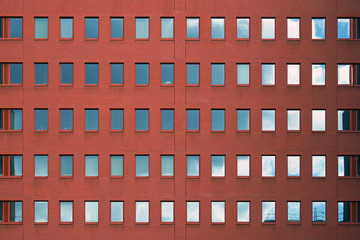 Old red brick wall with windows. Facade of office building with windows. Facade of an old red brick wall with windows.
