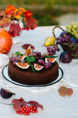 Autumn chocolate cake decorated with figs and grapes