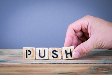 push. Wooden letters on the office desk, informative and communication background