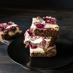 Chocolate cheesecake layered with brownie and dark cherrie. Chocolate cherrie cake. Pieces of chocolate cake. Winter dessert. Traditional american cuisine. Still life of food. Dark food photo.