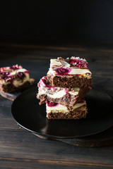Chocolate cheesecake layered with brownie and dark cherrie. Chocolate cherrie cake. Pieces of chocolate cake. Winter dessert. Traditional american cuisine. Still life of food. Dark food photo.
