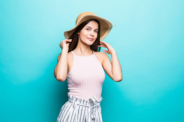 Fototapeta premium Happy young woman looking up in straw hat on blue background