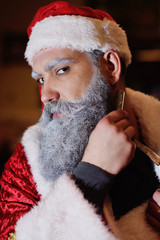 Santa Claus shaves his beard against the background of barbershop