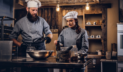 Chef teaching his assistant to bake the bread in the bakery.