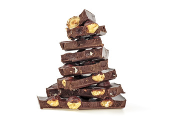 Delicious chocolate with nuts on white background, closeup. Broken chocolate bars.