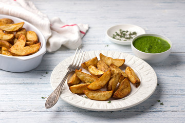 Baked potatoes with kale pesto sauce on a light blue background, selective focus. Delicious vegan homemade food