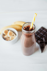 Banana and chocolate smoothie in the glass jar milkshakes, natural and organic drink