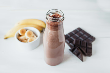Banana and chocolate smoothie in the glass jar milkshakes, natural and organic drink