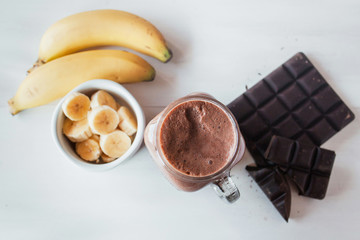 Banana and chocolate smoothie in the glass jar milkshakes, natural and organic drink