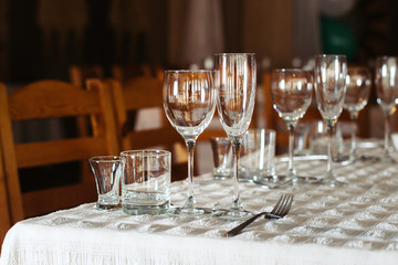 Served table with glasses on a white tablecloth in restaurant.