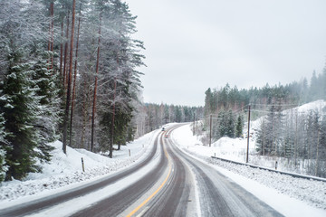 Car with lights on a snow covered road.