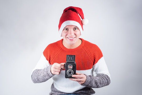 Santa Claus taking picture with old camera.