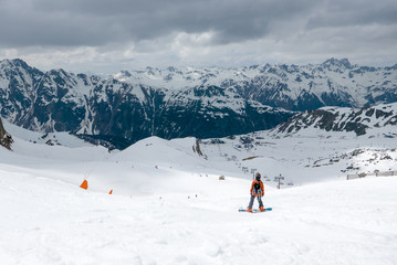 Fototapeta na wymiar Snowboarder preparing for a ride on snowy slope in ski resort
