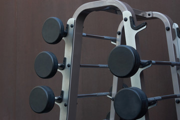 Sports equipment in gym. Barbells of different weight on stand