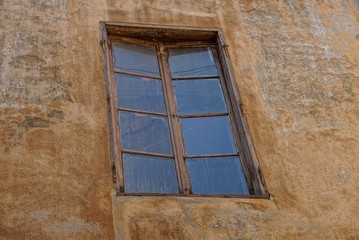old brown window on the concrete wall of the building