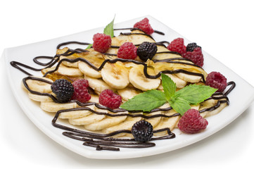 homemade crepes with chocolate cream, banana and blueberries on white background. pancakes