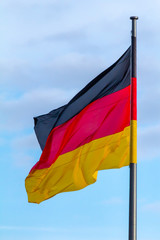 Federal Republic of Germany, German national flag waving on the blue sky background