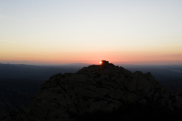 Aerial view of a spectacular sunset behind some rocky mountains in Sardinia, Italy.