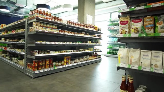 Grocery store interiors, with decked up shelves brightly lit in Warsaw Poland (moving gimbal shot)