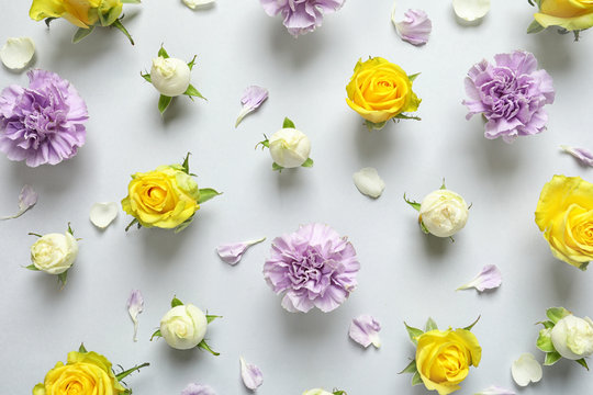 Flat lay composition with beautiful blooming flowers on grey background