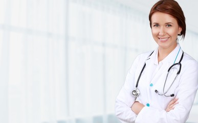 Attractive young female doctor on background