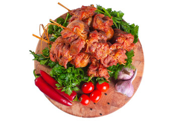Smoked pork shish kebab on skewers with vegetables and greens on white isolated in plan