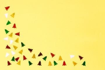 Small sparkling Christmas tree yellow background