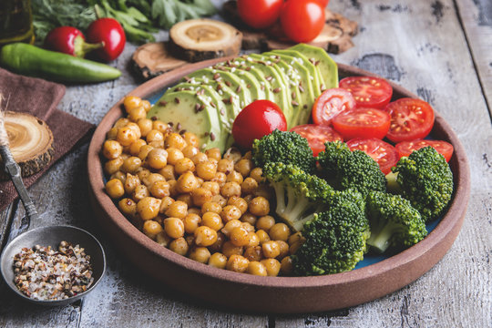 Healthy vegan salad with avocado , chickpeas , broccoli , tomato