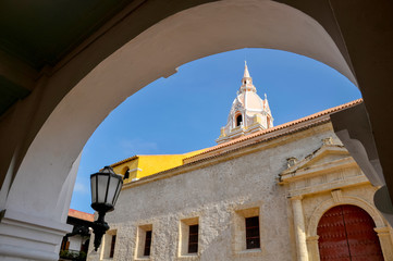 Classic colonial church facade with tower seen through building column, Cartagena. Colombia