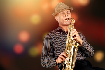 Close-up man playing on saxophone on blurred