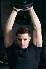 muscular man flexing his muscles working out in a gym