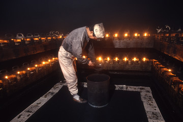 伝統工芸の墨作り、採煙蔵の中で菜種油に浸した燈芯を燃やし皿についた煤を採取する