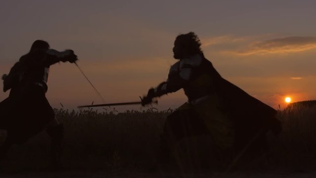 Fight at sunset. Slow motion wide shot.