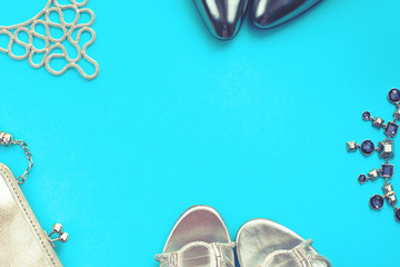 Set of fashion accessories flat lay shoes handbag necklace jewelry silver color on blue background...