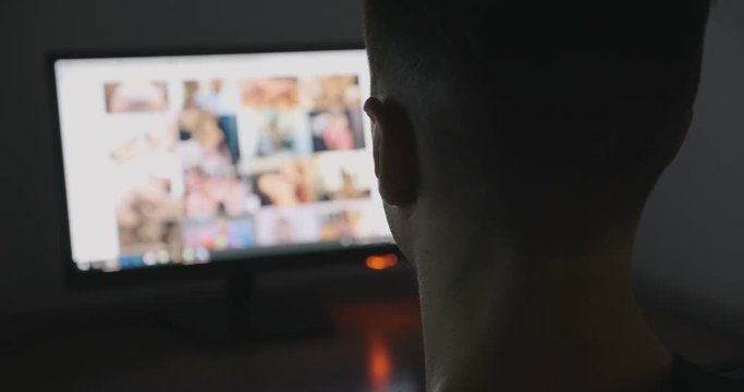Young Man secretly watching porn sites at night.