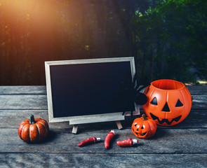 Halloween background. Spooky pumpkin, Black spider, chalkboard on wooden floor with moon and dark forest. Halloween design with copyspace