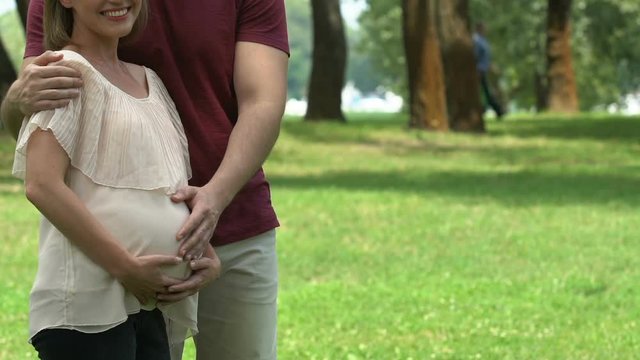 Happy pregnant couple embracing, successful vitro fertilization, family planning