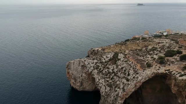 Revealing shot of blue groto and it's viewpoint, flying backwards. In Malta