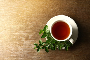 Herbal hot tea in white glass with saucer Have a leaf on the side, look freshly laid on the wood floor in the morning.
