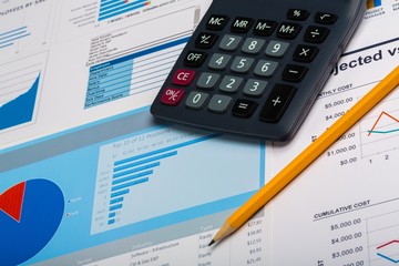 Pencil and Calculator on Business Graphs and Charts