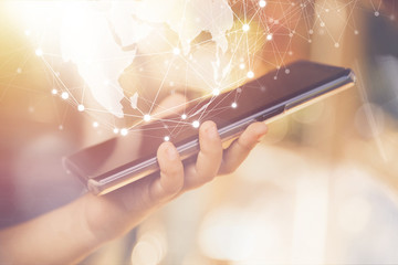 hand holding smartphone with global network, business and technology concept.