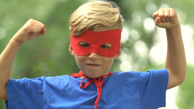 Strong superboy wearing mask and costume showing strength, self-confidence