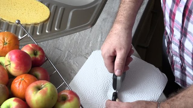 The man is sharpening a kitchen knife