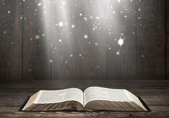 Open book on old wooden table.