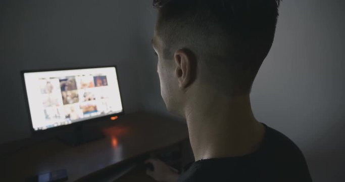 Young Man secretly watching porn sites at night.