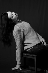 Black and white photo of beautiful brunette girl posing in studio.