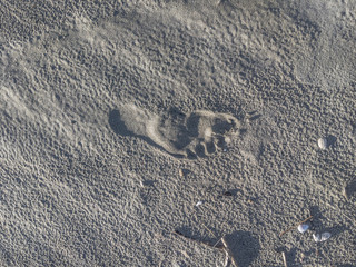 footprint impression in rippling sand with deep shadow