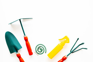 Mosquito protection for garden. Mosquito coil and spray near garden tools on white background top view copy space