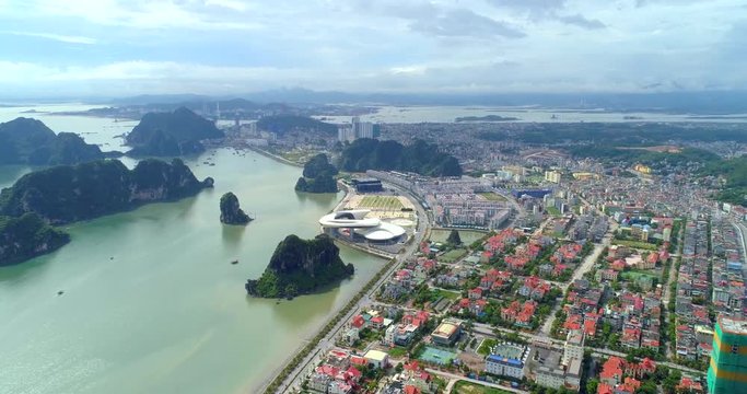 4k Aerial view over city and park with Bai Tho karst mountain Ha long bay. Halong City, Vietnam