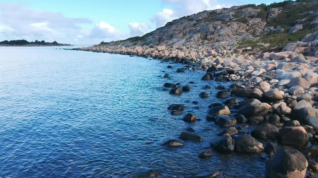 Aerial drone shot of a rocky beach ocean coastline on the west coast of Sweden in Halland, outside of Gothenburg.
